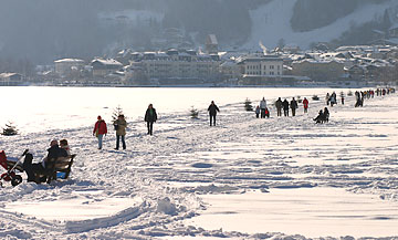 Marked paths are traversing the frozen lake in winter.